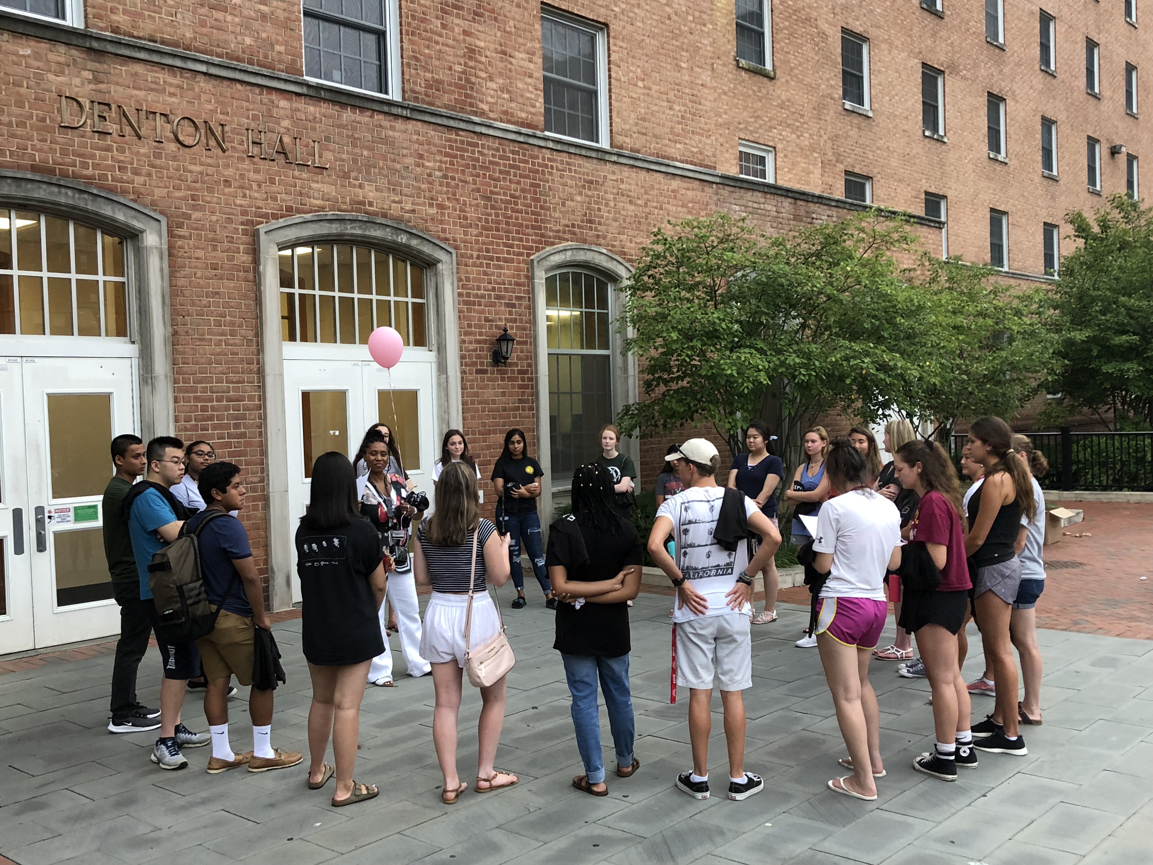 group of students gather outside dorm